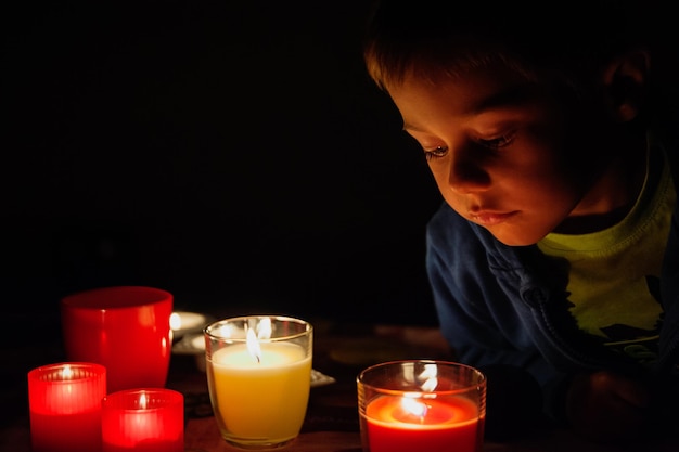 Close-up of boy looking at candles
