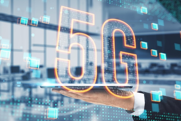 Close up of businessman hand holding tablet with glowing 5g hologram