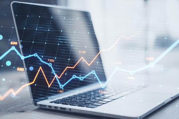 Close up of laptop with glowing business chart on blurry background Stock growth and financial graph concept Double exposure