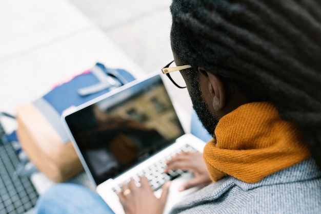Close-up of man using laptop at home