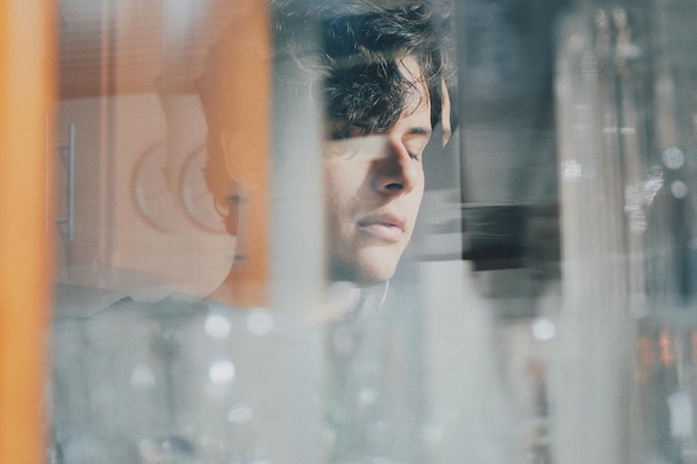Close-up of young man seen through glass window
