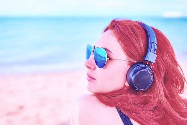 Close-up portrait of woman wearing sunglasses at beach