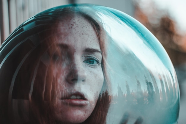 close-up portrait of young woman wearing glass helmet in head outdoors