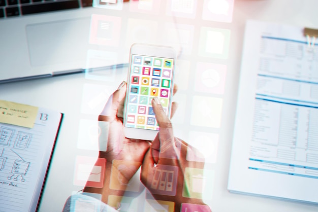 Closeup hands and smartphone with icons hologram and business documents with website info typing and connection Woman employee and consultant with cellphone screen and holographic with software