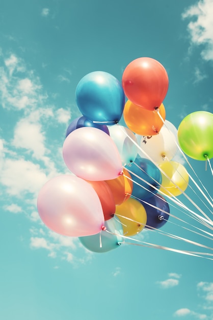 colorful festive balloons over blue sky with a retro vintage instagram filter effect. 