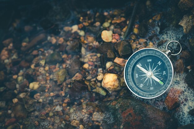 Compass of tourists on stone at riverside
