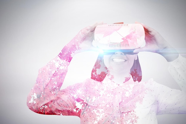 composite image of smiling woman using virtual reality glasses
