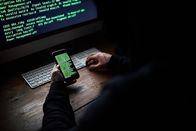 computer cellphone and hands for hacker coding and scam or fintech for cyber security dark software and online crime for data programmer person digital and thief on internet with technology