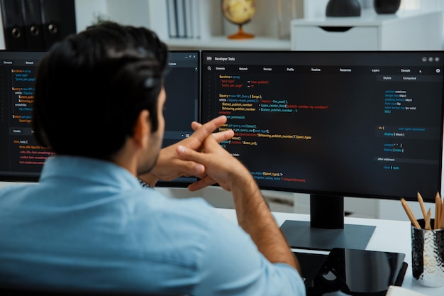 concentrating in smart it developer working coding on two pc screen surmise