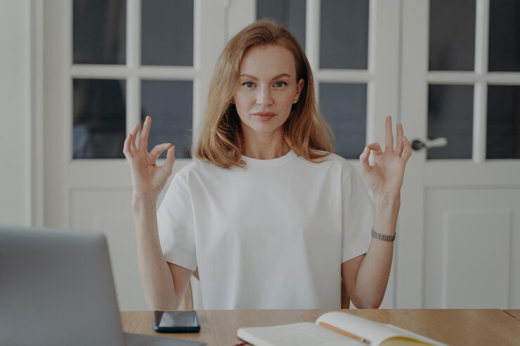 Fotografie confident woman gestures ok sitting at the desk in apartment successful mid adult businesswoman