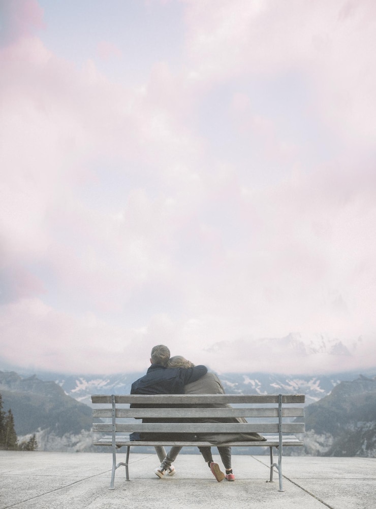 Fotografie couple sitting on bench against cloudy sky