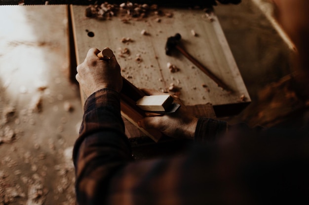 cropped hand of carpenter working at workshop