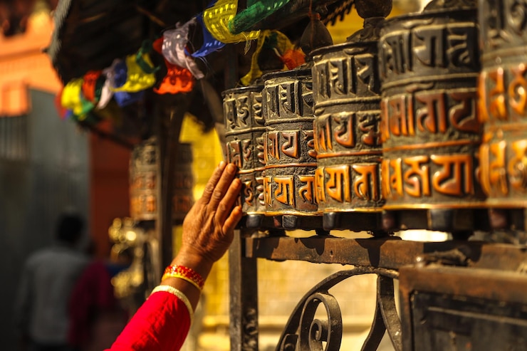 Fotografie cropped image of woman touching prayer wheels in temple