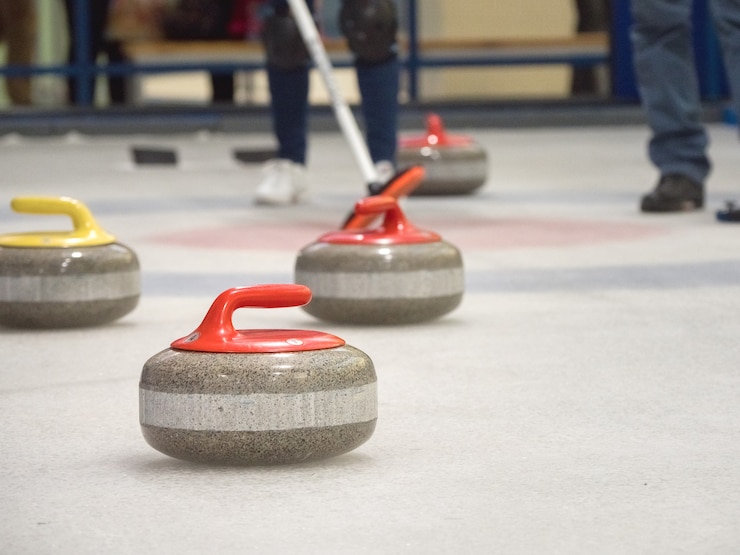 Fotografie curling stone on ice of a indoors rink.