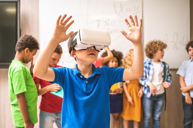 cute boy using virtual reality simulator in classroom