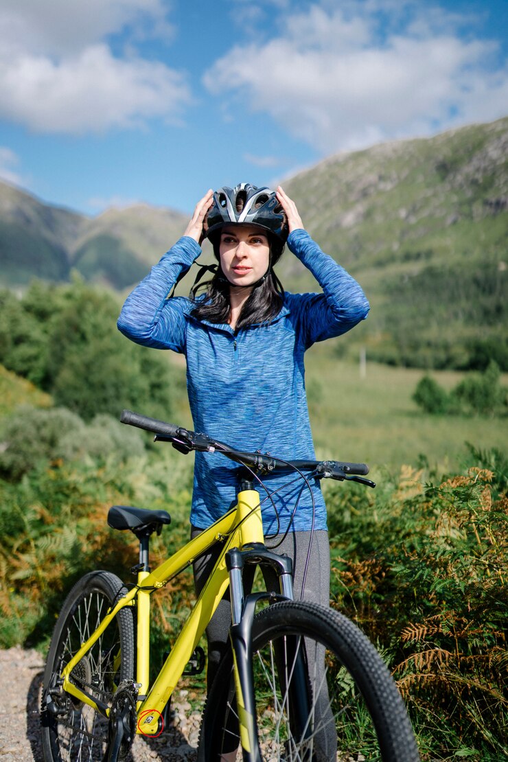 Fotografie cyclist putting on her bike helmet