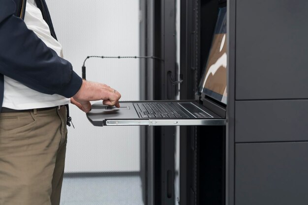 Detailní záběr rukou datového centra Engineer používá klávesnici na superpočítači. Specializované zařízení serverové místnosti s mužským správcem systému, který pracuje s datovou ochranou sítě pro kybernetickou bezpečnost.