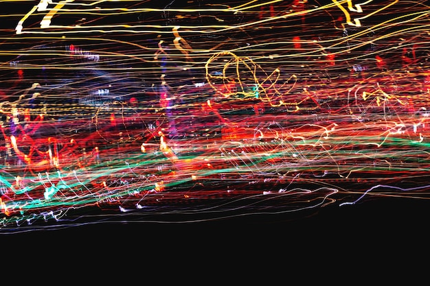 Digital composite image of light trails against black background