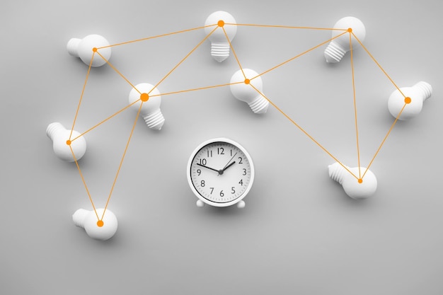 Directly above shot of light bulbs with clock on white background