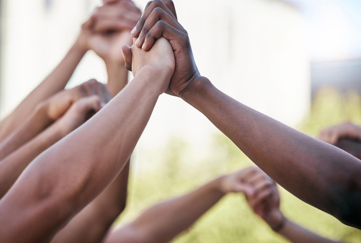Fotografie diversity holding hands and support with solidarity and prayer circle outdoor together group hands in air motivation and team building for collaboration help trust and friends hope for community