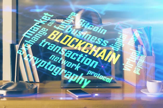 Double exposure of blockchain theme hologram and table with computer background Concept of bitcoin crypto currency