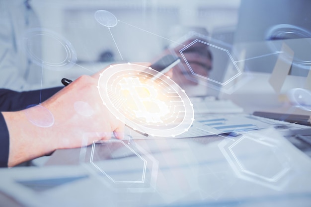 Double exposure of man's hands holding and using a phone and crypto currency blockchain theme drawing