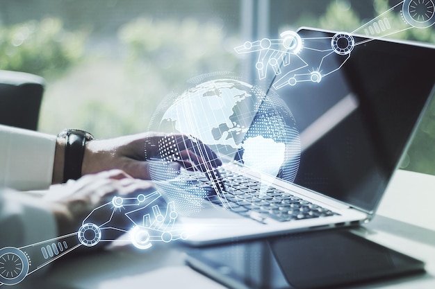 Double exposure of robotics technology with world map hologram and hands typing on laptop on background Research and development software concept