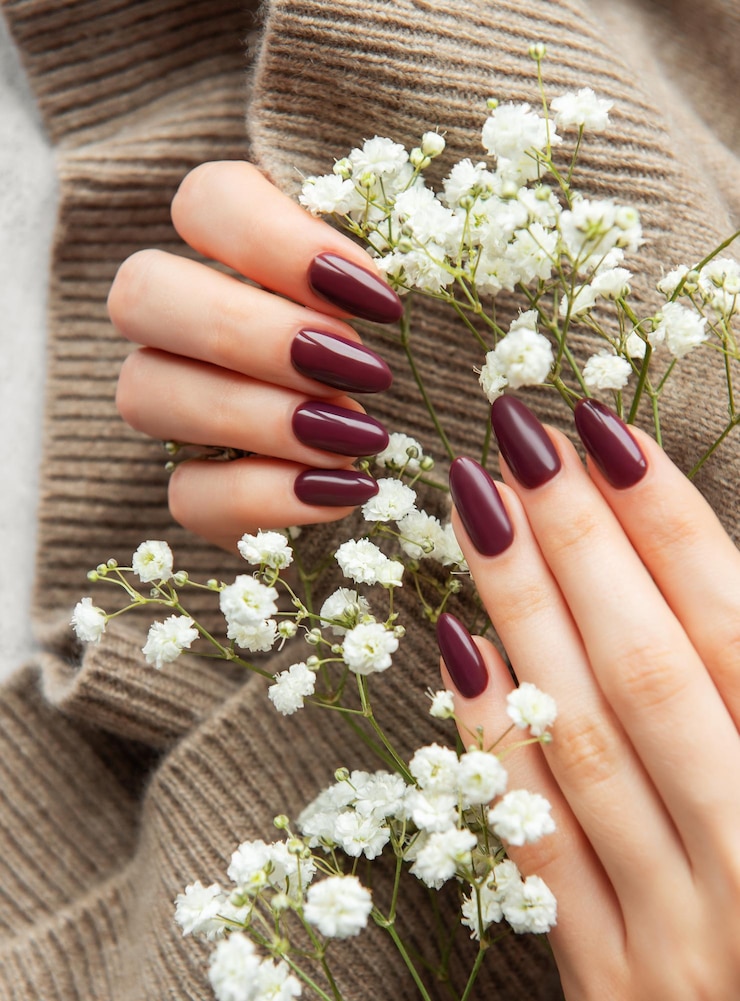 Fotografie elegant deep burgundy nails displayed alongside delicate white flowers