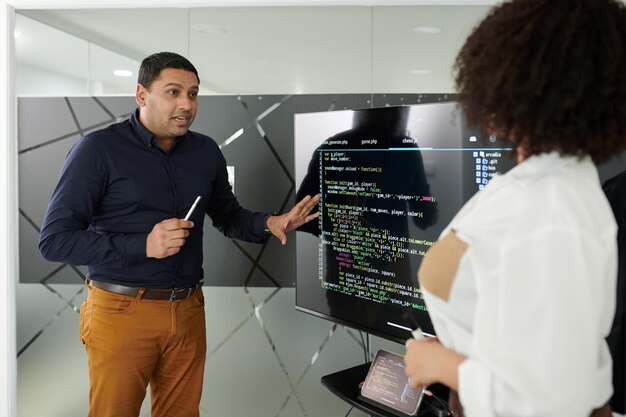Emotional team leader discussing bugs in programming code with developer