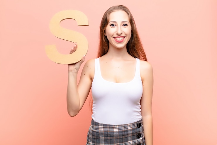Fotografie excited, happy, joyful, holding the letter s of the alphabet to form a word or a sentence.