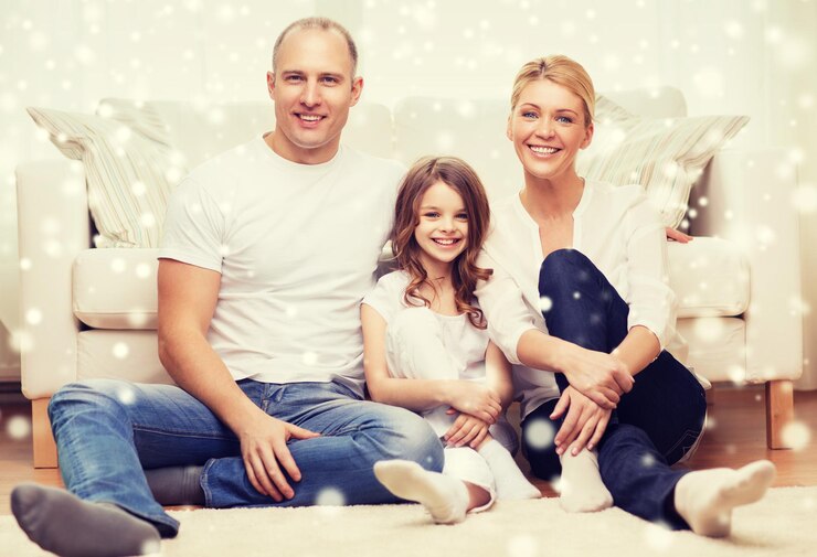 Fotografie family, childhood, people and home concept - smiling parents with little girl sitting on floor at home