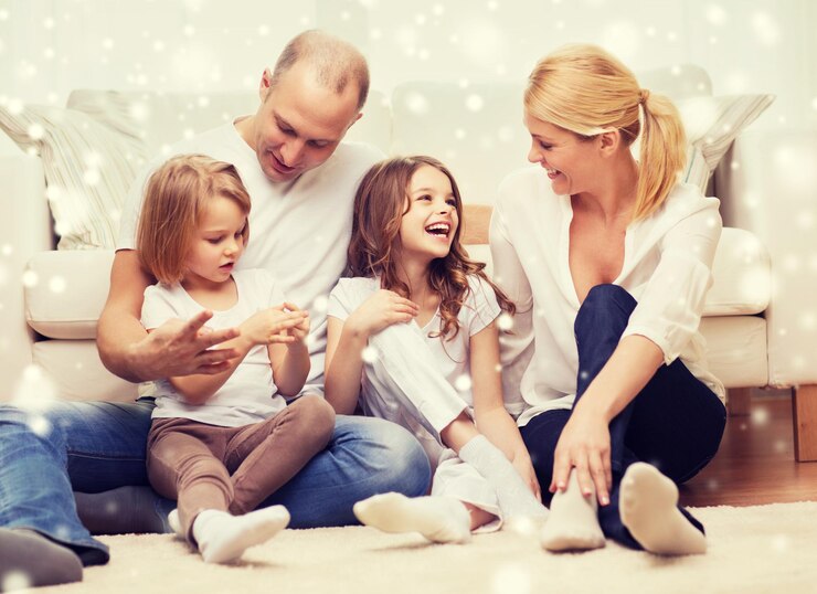 Fotografie family, childhood, people and home concept - smiling parents with two little girls sitting on floor at home