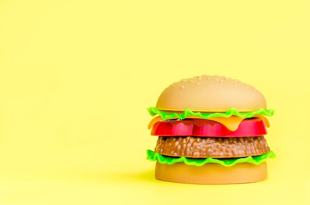 Fast food. plastic hamburger on a yellow background. copy space