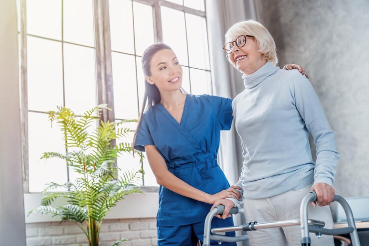 Fotografie female asian nurse helping senior woman to walk with walker at home