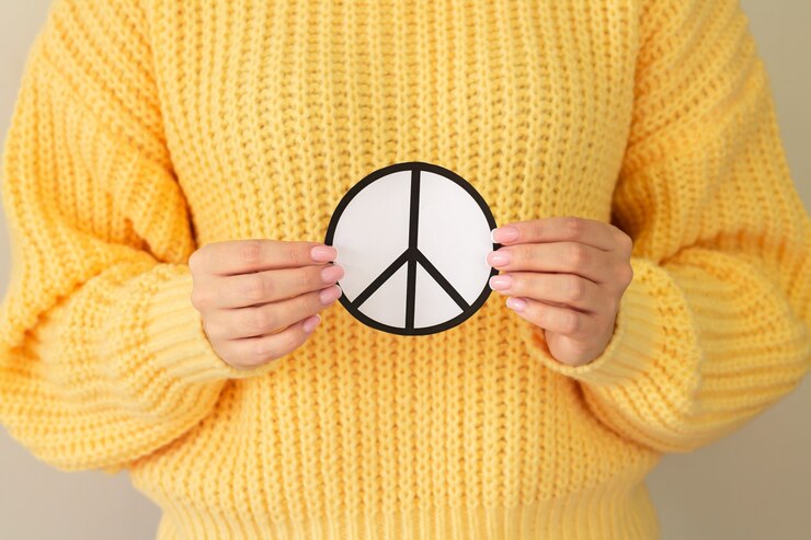 Fotografie female hands holding paper peace symbol. freedom, love and peace concept