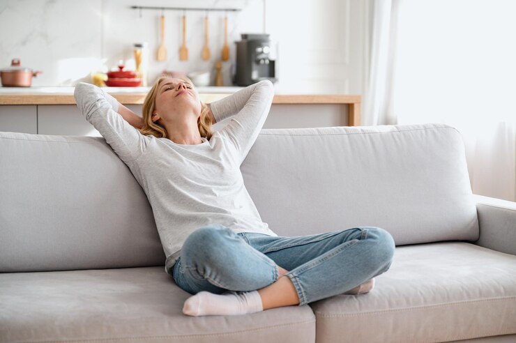 Fotografie female rest in cozy living room holding hands behind her head