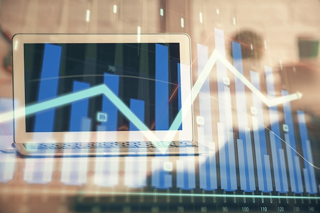 Financial chart drawing and table with computer on background Multi exposure Concept of international markets