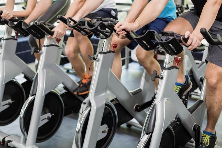 Fotografie fit group of people using exercise bike together at gym