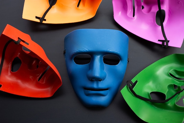 five face masks on dark surface.
