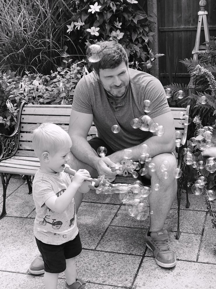 Fotografie full length of father and son sitting outdoors