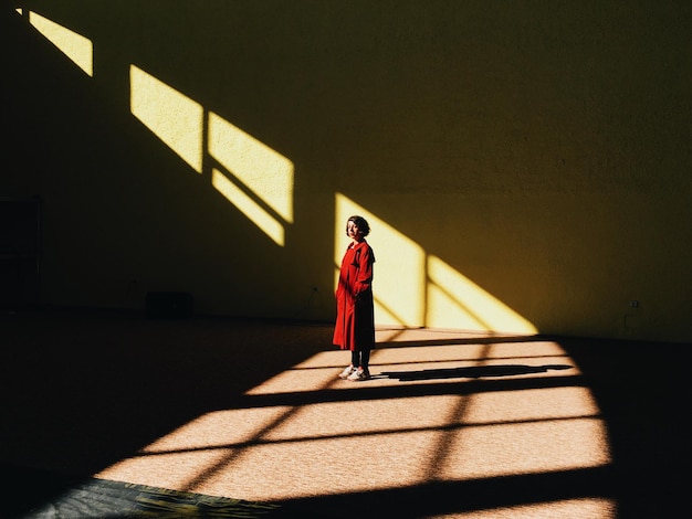 Full length of woman standing against wall
