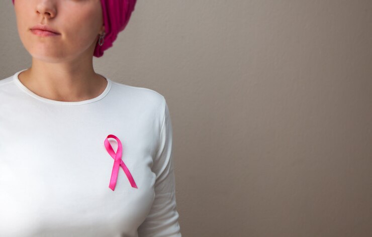 Fotografie girl in a white t-shirt with a pink ribbon on her breast defeating cancer