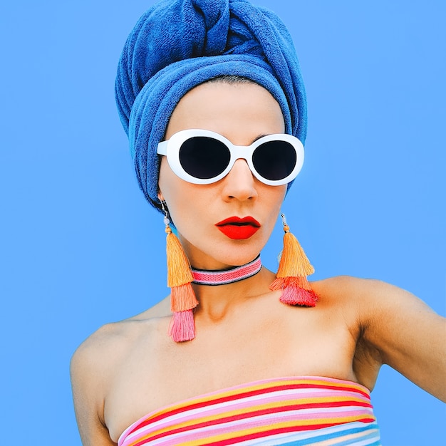 girl in fashionable beach accessories. head scarf, sunglasses and earrings. beach fashion look
