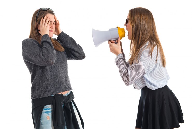 Fotografie girl shouting at her sister by megaphone  