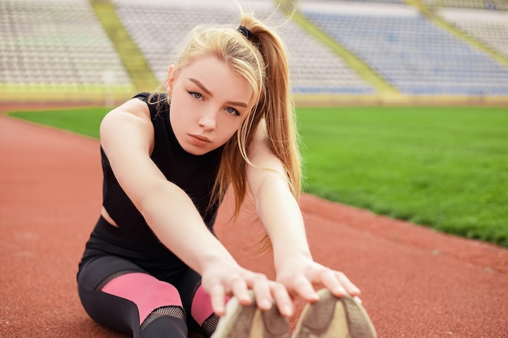 Fotografie girl stretches at the stadium