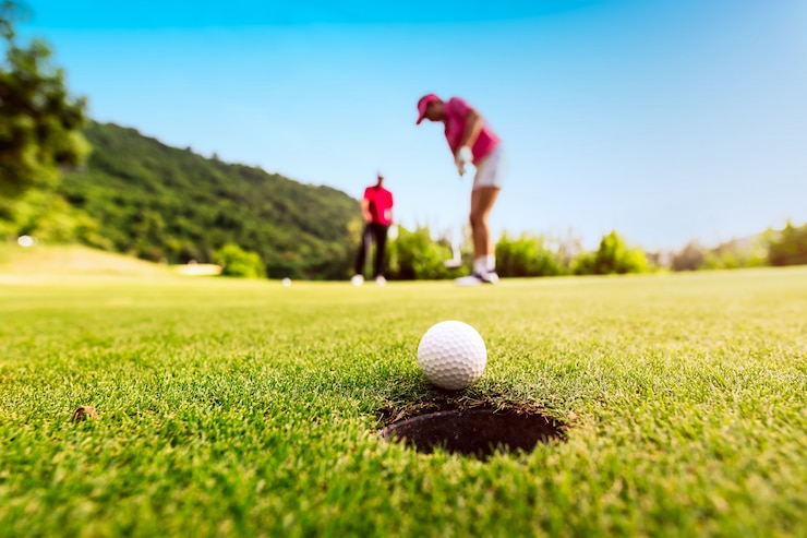 Fotografie golfer focus putting golf ball into the hole during sunset,healthy and lifestyle concept.