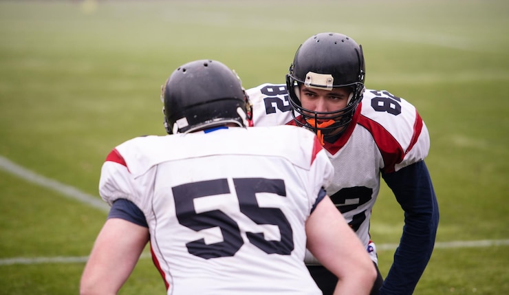 Fotografie group of young professional american football players in action during training on the field