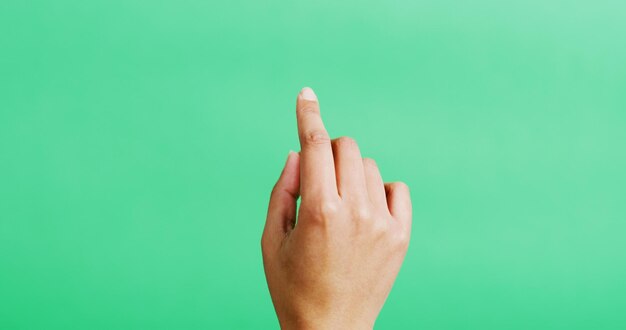 Hand click and mockup space in studio gesture and point with scroll empty and green background Person finger and interface or responsive display with user experience touch and virtual screen