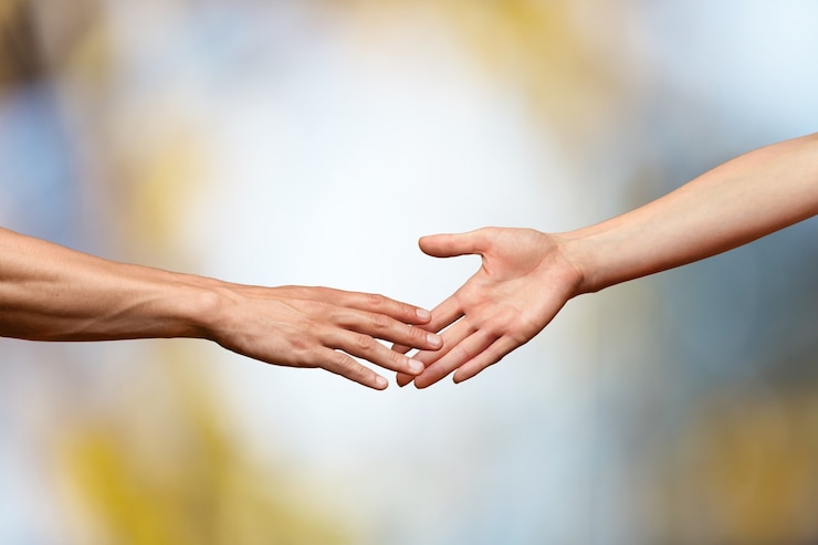 Fotografie hands reaching out and touching each other on a bokeh background