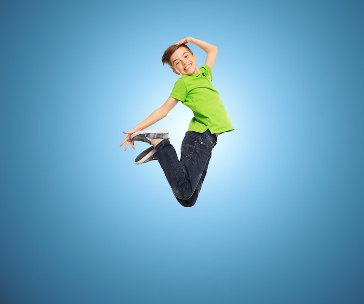 Fotografie happiness, childhood, freedom, movement and people concept - smiling boy jumping in air over blue background